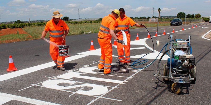 Trabajadores pintando señalización horizontal en una pista